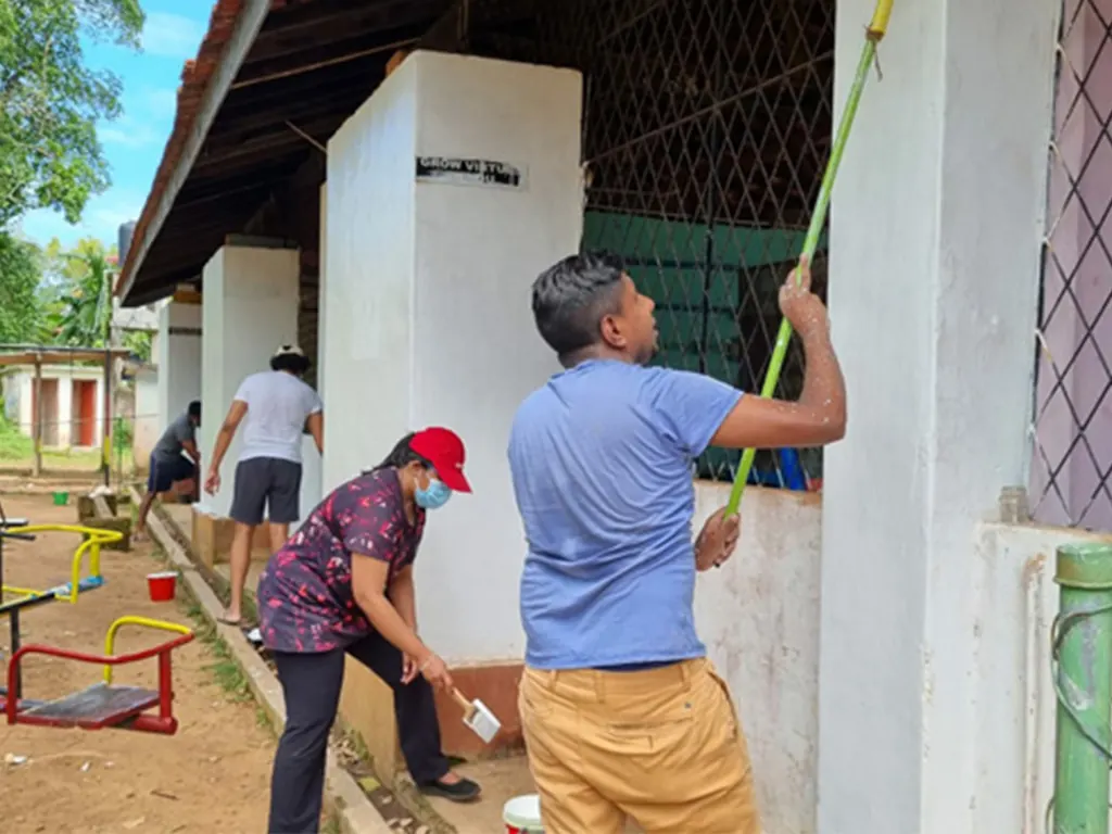 Members painting a building during a community project